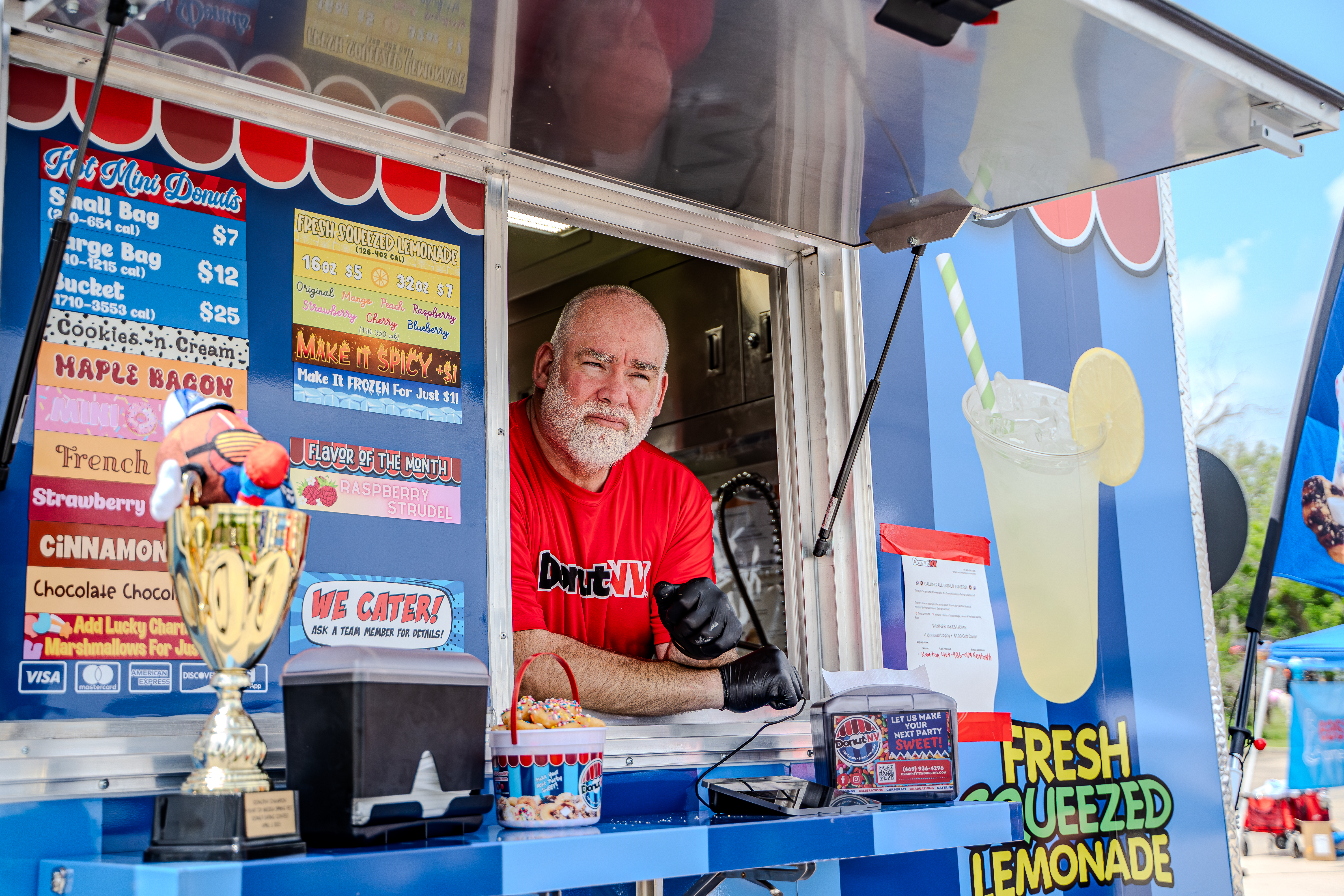 DonutNV franchisee owner at service window with trophy