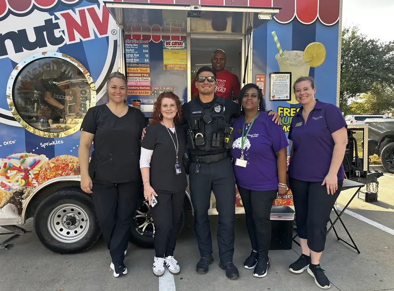 Police officer and community members posing at DonutNV trailer