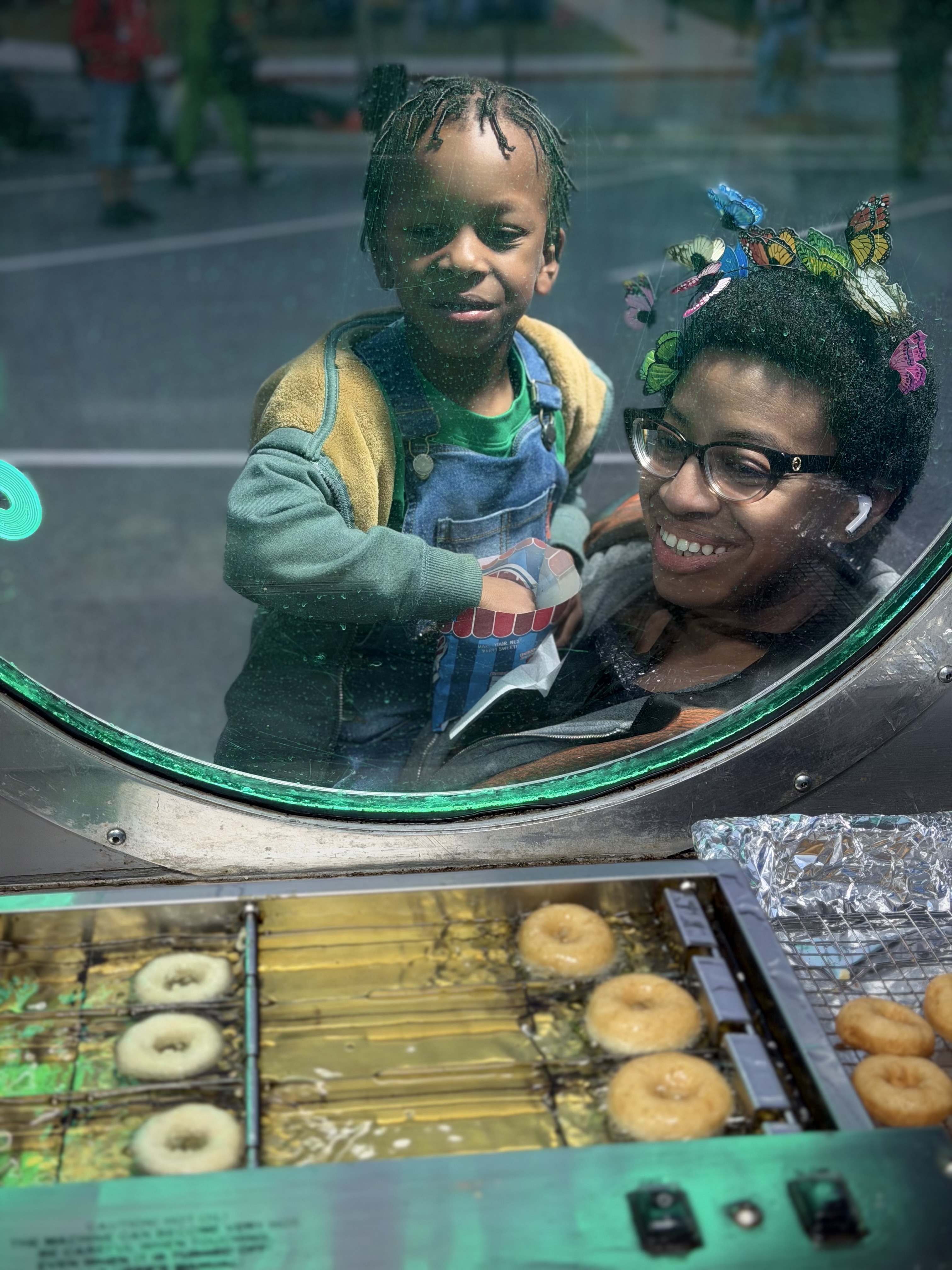 Mother and child watching donuts being made through the DonutNV porthole window