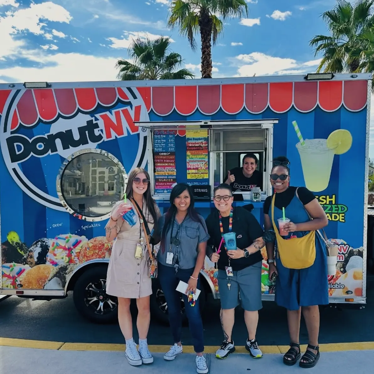 Happy customers with DonutNV lemonades in front of trailer with palm trees